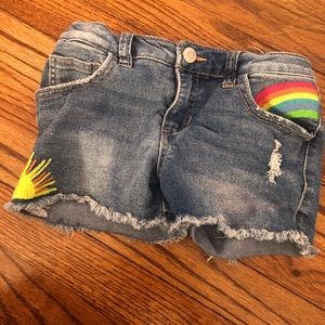 Girls denim shorts with rainbow and sun patches.